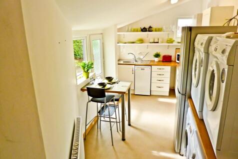 A bright and modern kitchen featuring ample cou...
