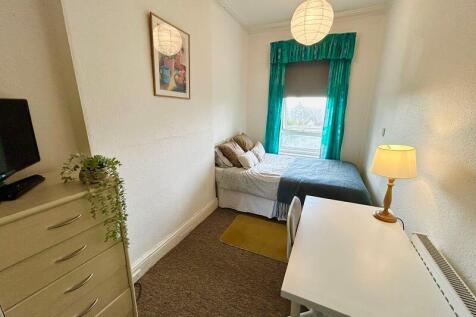 Cozy double bedroom featuring large windows tha...