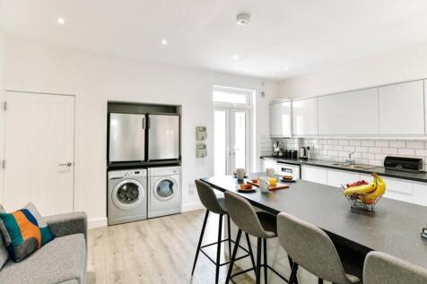 Modern kitchen featuring sleek cabinetry, ample...