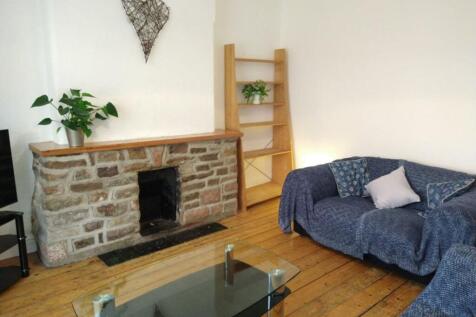 A cozy living room featuring a charming stone f...