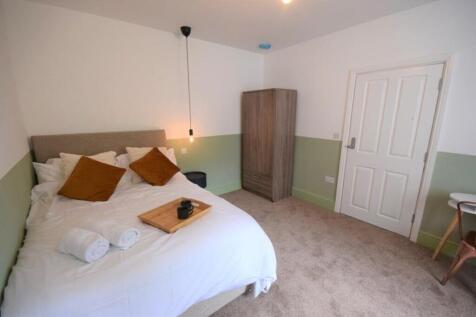 This inviting double bedroom features a comfort...