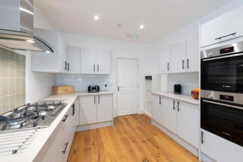 This modern kitchen features sleek cabinetry, h...