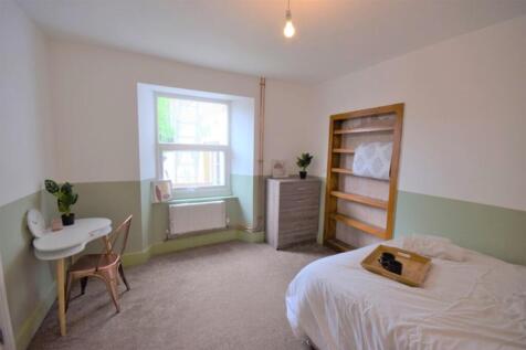 This charming double bedroom features a cozy at...