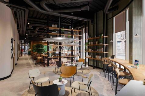 A spacious and modern communal workspace featur...