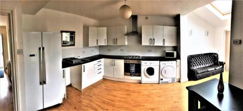 Spacious and modern kitchen featuring sleek whi...