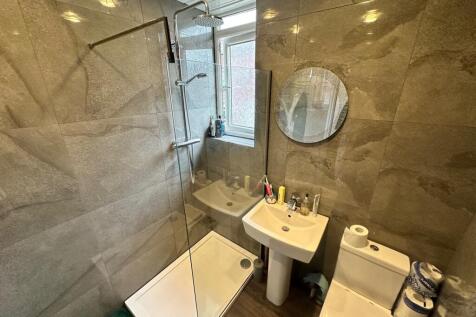 This modern bathroom features a spacious shower...
