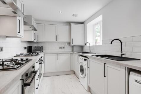 A modern and clean kitchen with ample space and...