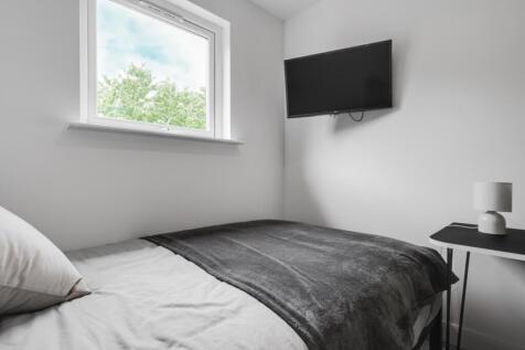A modern double bedroom featuring a cozy bed an...