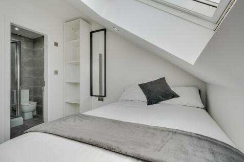 A bright and modern double bedroom featuring an...