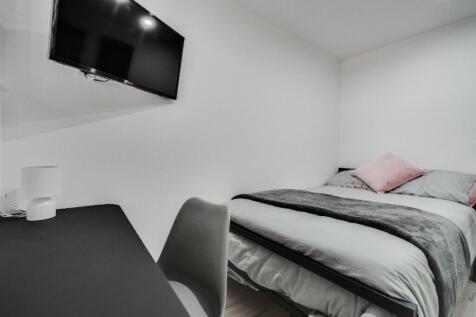 A cozy and modern double bedroom featuring a co...
