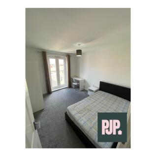 Spacious double bedroom featuring large windows...