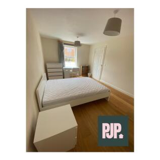 Spacious double bedroom featuring ample natural...
