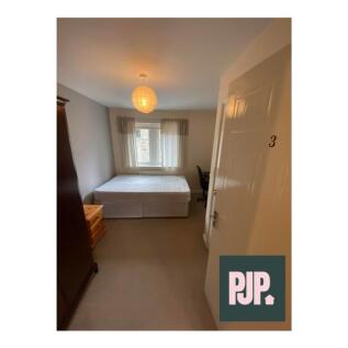 Spacious double bedroom featuring ample natural...