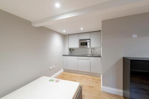 A modern and clean kitchenette with ample stora...