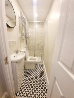 A modern bathroom featuring a sleek shower area...