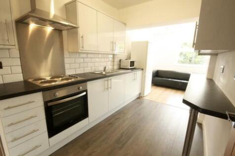 A modern kitchen featuring sleek white cabinetr...