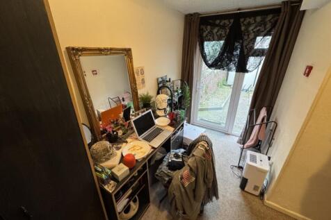 A cozy double bedroom featuring a stylish desk ...