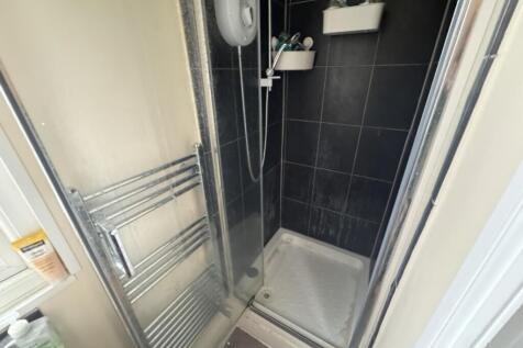 A modern shower area featuring sleek black tile...