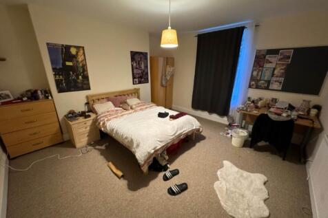 Spacious double bedroom featuring a cozy bed an...