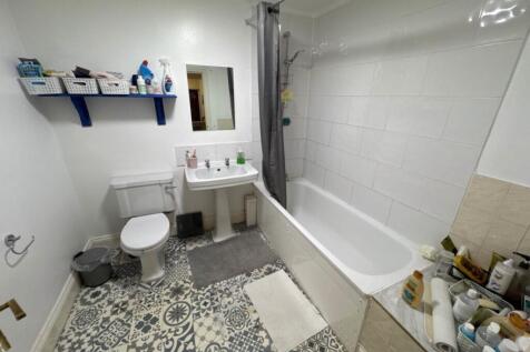 A well-maintained bathroom featuring a bathtub ...