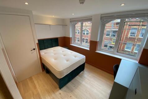 Spacious double bedroom featuring large windows...