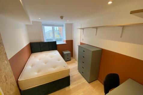 This spacious double bedroom features a comfort...