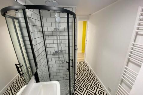 This modern bathroom features a stylish walk-in...