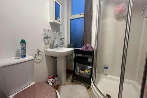 A tidy bathroom featuring a shower and essentia...