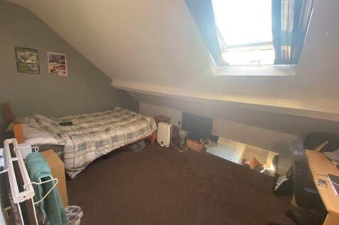 A cozy double bedroom featuring a skylight that...
