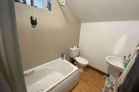 A tidy bathroom featuring a bath and essential ...