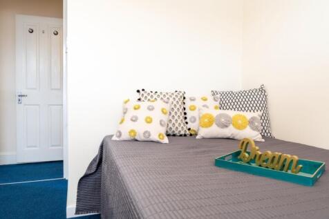 A cozy double bedroom featuring a neatly made b...