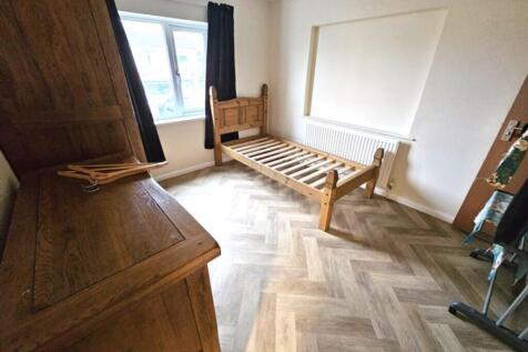 A cozy double bedroom featuring a warm wooden b...