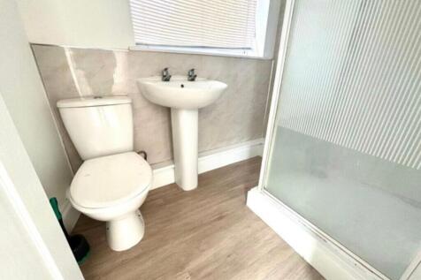 A modern and tidy bathroom featuring a shower a...