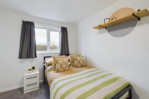 A bright and inviting double bedroom with styli...