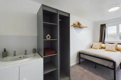 A bright and tidy double bedroom featuring mode...