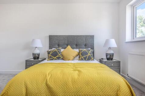 This stylish double bedroom features a cozy des...