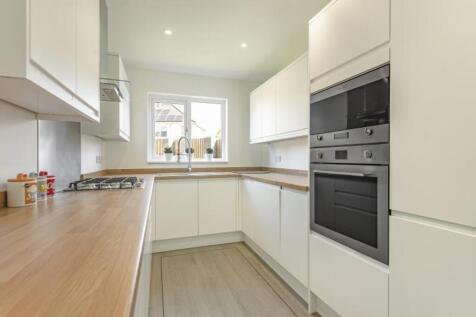 A modern kitchen featuring sleek cabinetry and ...