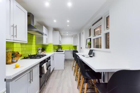 A modern and spacious kitchen with bright green...