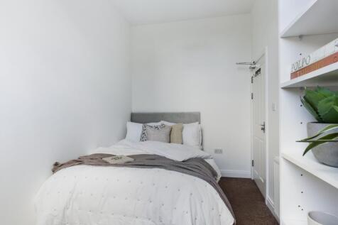 A bright and inviting double bedroom with a coz...