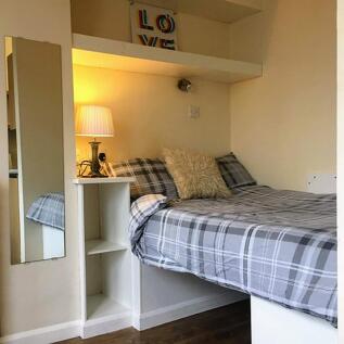 This inviting double bedroom features a cozy la...