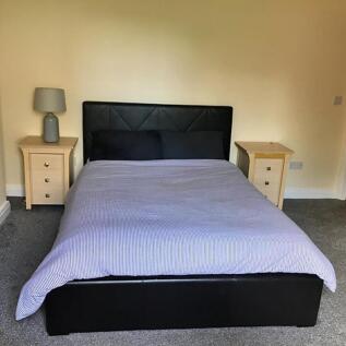 A spacious double bedroom featuring a comfortab...