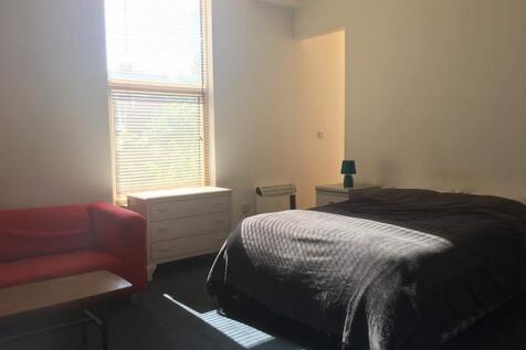 Spacious double bedroom featuring abundant natu...