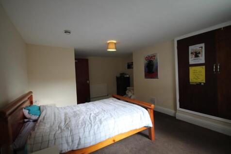 Spacious double bedroom featuring a cozy wooden...