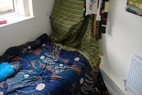 A cozy double bedroom featuring a vibrant quilt...