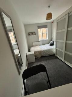 This inviting double bedroom features a cozy at...
