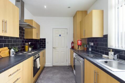 A bright and modern kitchenette with ample stor...