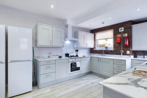 A spacious and modern kitchen with sleek cabine...