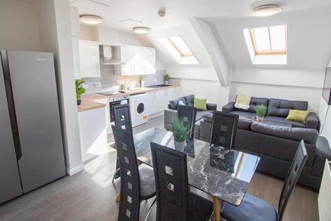 This contemporary kitchen and living area boast...