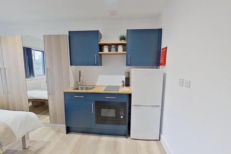 This modern kitchenette features sleek blue cab...