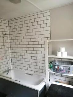 A modern bathroom featuring a clean white batht...